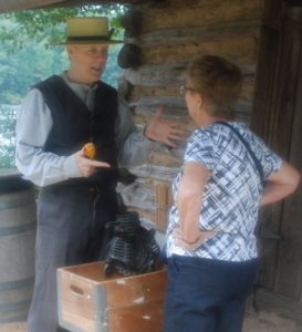 Yates Mill volunteer explaining corn sheller to visitor